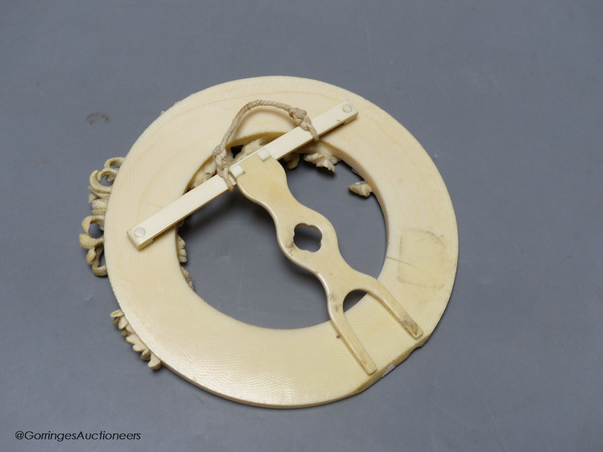 A circular carved ivory picture frame